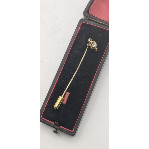 38 - A gold stick pin having a yellow gold pendant tested as 18ct gold set with a diamond on a yellow gol... 