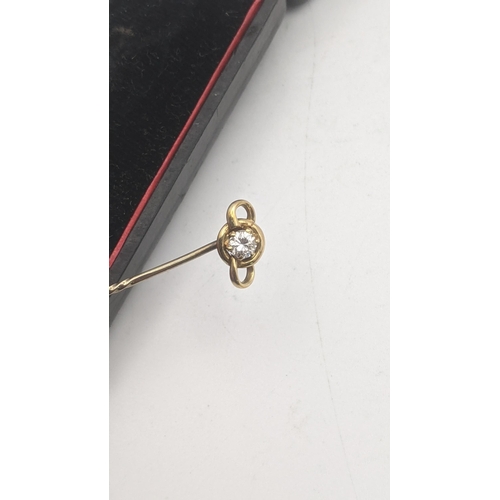 38 - A gold stick pin having a yellow gold pendant tested as 18ct gold set with a diamond on a yellow gol... 