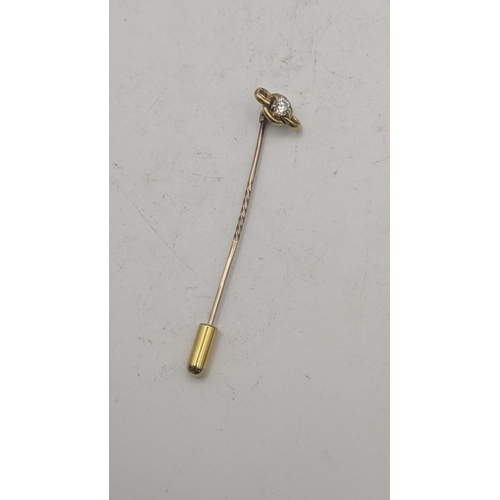 38 - A gold stick pin having a yellow gold pendant tested as 18ct gold set with a diamond on a yellow gol... 