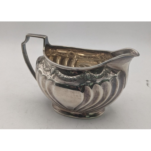 46 - A silver milk jug having embossed decoration hallmarked Sheffield 1888, 151.2g
Location: CAB 1
If th... 