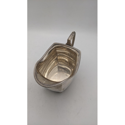 50 - Silver to include a sauce boat on four ball feet hallmarked Chester 1939, together with a cream jug,... 