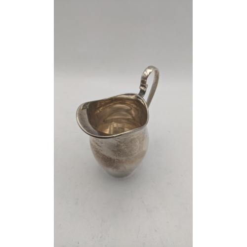 50 - Silver to include a sauce boat on four ball feet hallmarked Chester 1939, together with a cream jug,... 