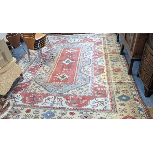 338 - A Turkish Milas Toban hand woven carpet having geometric designs, three central lozenge motifs and t... 