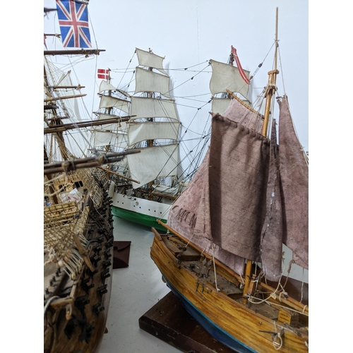 463 - A fleet of wooden model sailing vessels to include a large three-masted model of HMS Victory, and a ... 