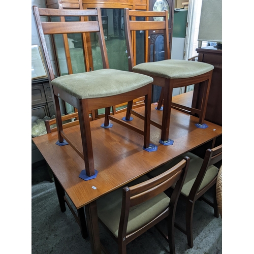 477 - A mid-century teak extending dining table on shaped square legs 74cm x 127cm x 81cm, with six matchi... 