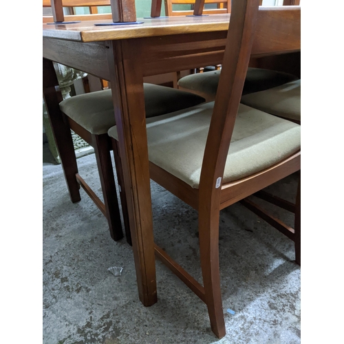 477 - A mid-century teak extending dining table on shaped square legs 74cm x 127cm x 81cm, with six matchi... 