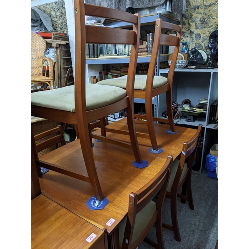 477 - A mid-century teak extending dining table on shaped square legs 74cm x 127cm x 81cm, with six matchi... 