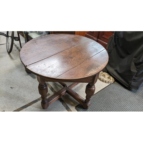 551 - An early 20th century copy of a 17th century oak demi lune fold over table having turned legs, unite... 