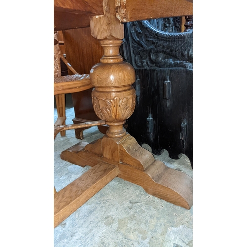 601 - A mid 20th century oak refectory table on carved cup and cover columns and block feet, 76cm high x 1... 