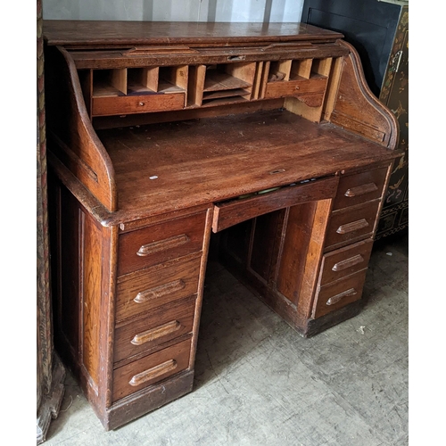 279 - An early/mid 20th century oak roll top tambour desk, opening to reveal fitted drawers and pigeon hol... 