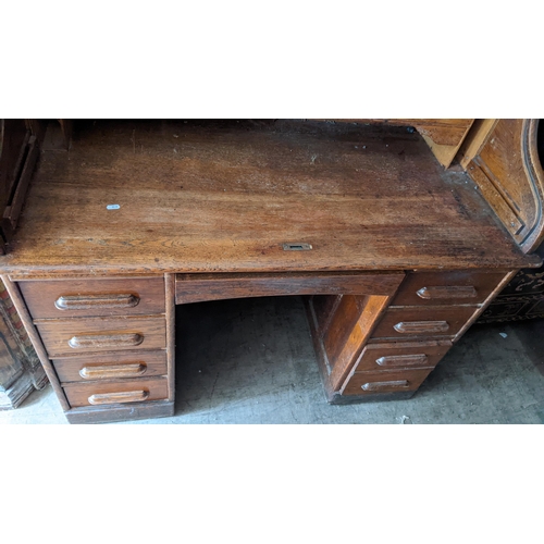 279 - An early/mid 20th century oak roll top tambour desk, opening to reveal fitted drawers and pigeon hol... 