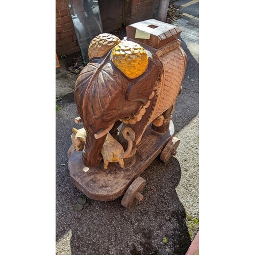 287 - An Indian teak carved model of an elephant mounted on a cart, 89cm high x 83cm wide
Location:RC
If t... 