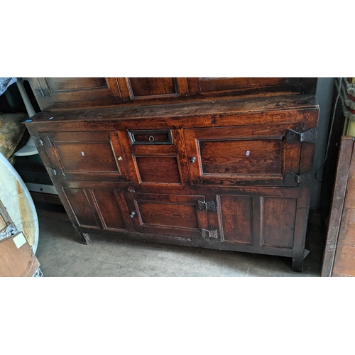 289 - An early 18th century oak court cupboard / didarn, dated 1713, having panelled doors, carved cornice... 