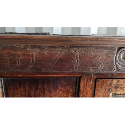 289 - An early 18th century oak court cupboard / didarn, dated 1713, having panelled doors, carved cornice... 