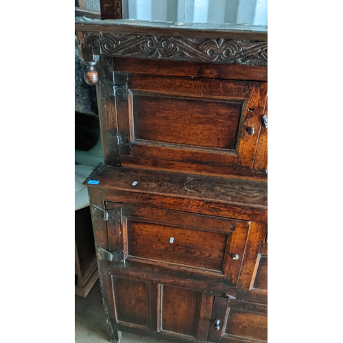 289 - An early 18th century oak court cupboard / didarn, dated 1713, having panelled doors, carved cornice... 