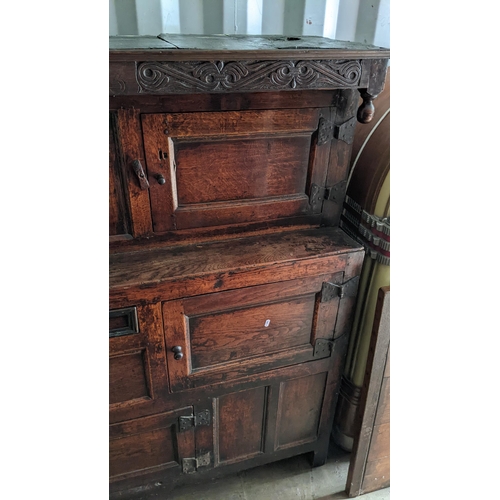 289 - An early 18th century oak court cupboard / didarn, dated 1713, having panelled doors, carved cornice... 