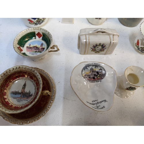 306 - A collection of Crestware to include various examples of the National exhibitions at Wembley, London... 