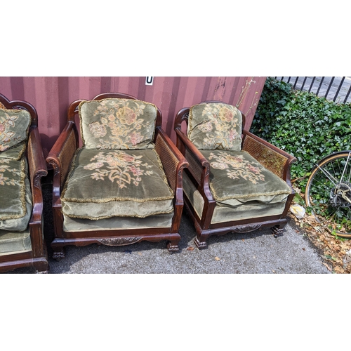 327 - An early 20th century Bergere three piece suite, the mahogany frames having scrolled arms, cloud sha... 