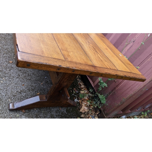 329 - A large 19th century French farmhouse oak dining table, having two trestle ends united by a single s... 