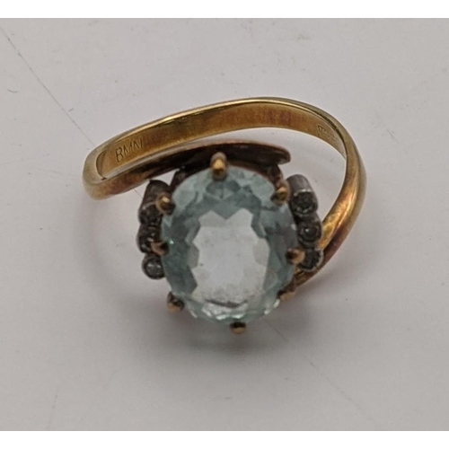 100 - An 18ct gold ring having a central oval cut aquamarine in claw setting flanked by diamonds, size O 1... 