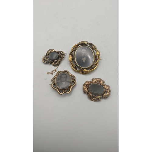 61 - Four Victorian mourning brooches to include three two sided brooches and the other mounting a pictur... 