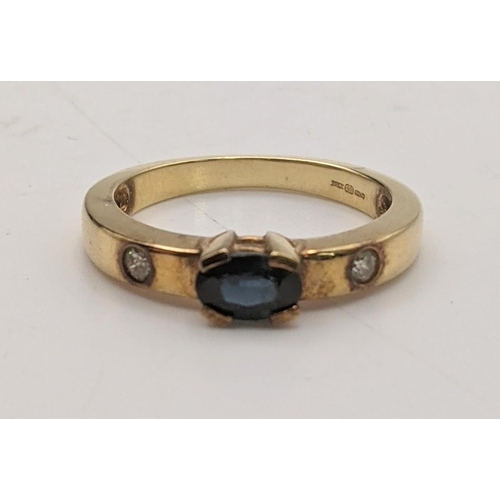 98 - An 18ct gold ring faceted with an oval blue sapphire, flanked by diamonds, size M 1/2, 4.1g
Location... 