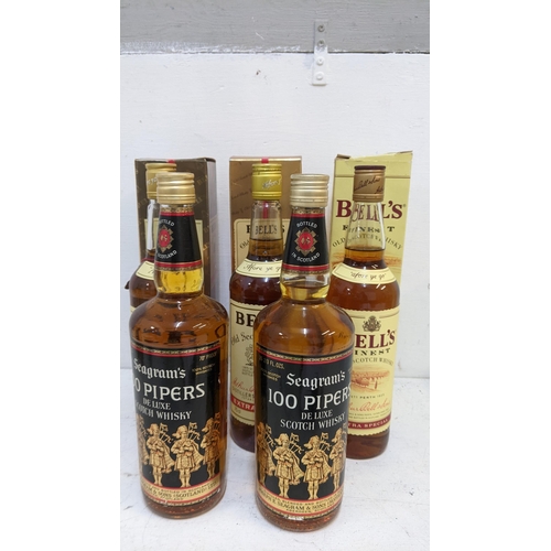 69 - Three boxed bottles of Bells Old Scotch Whisky, 2 x 70cl, 1 x 75cl and two bottles of Seagram's 100 ... 