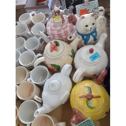 234 - A quantity of novelty teapots, commemorative mugs, wooden models of animals and other items. Locatio... 