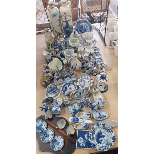 236 - A quantity of Delft and similar blue and white ornaments to include a cow creamer, windmills and a p... 