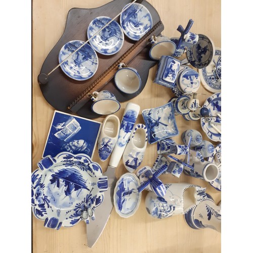 236 - A quantity of Delft and similar blue and white ornaments to include a cow creamer, windmills and a p... 