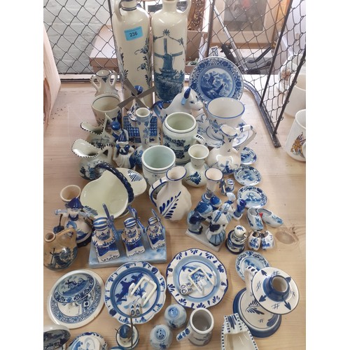 236 - A quantity of Delft and similar blue and white ornaments to include a cow creamer, windmills and a p... 