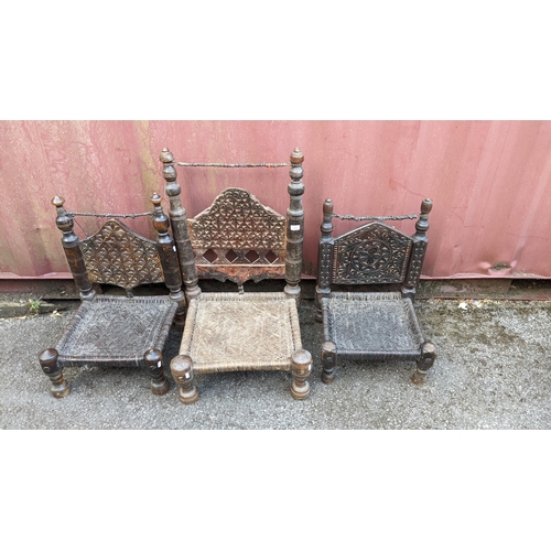 538 - Three antique Pakistan hardwood low chair with carved and turned ornament and woven seats on turned ... 