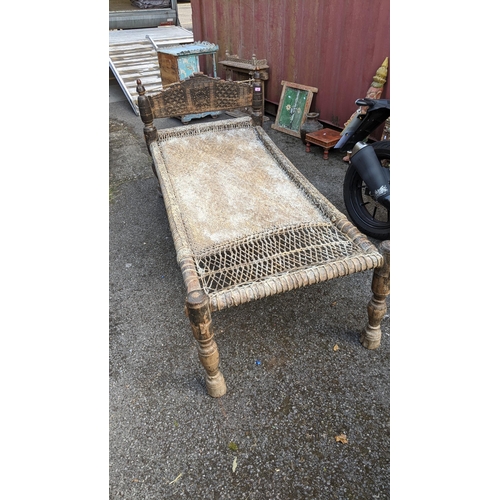 539 - An antique Pakistan hardwood and pine bed with a carved headboard on turned legs Location: Blue Con
... 