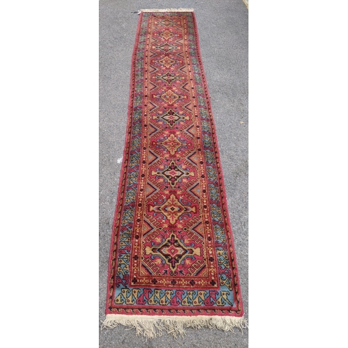 509 - A wool Eastern Turkestan Kashquai runner with eleven repeated central medallions five of one design ... 