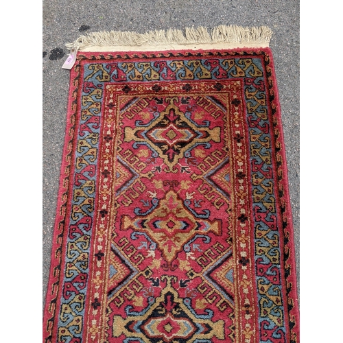 509 - A wool Eastern Turkestan Kashquai runner with eleven repeated central medallions five of one design ... 