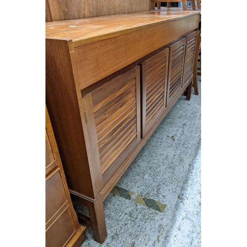 554 - A mid-century teak sideboard, two drawers above four louvred cupboard doors on square legs 75cm x 15... 