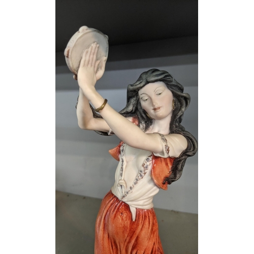 511 - A figure of a gypsy dancer with a tambourine, on a square wooden plinth by Giuseppe Armani, Florence... 