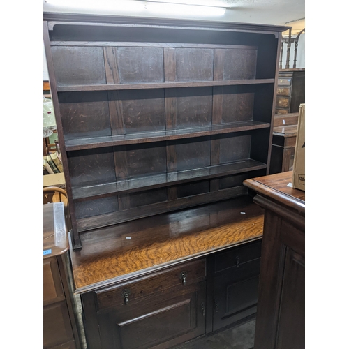 558 - An early to mid 20th century oak dresser, three open plate shelves above a base of two short drawers... 