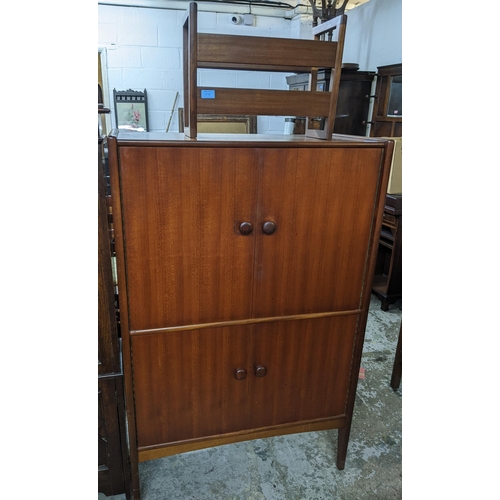 559 - A Younger Ltd mid 20th century teak drinks cabinet, twin doors revealing a fitted interior of glass ... 