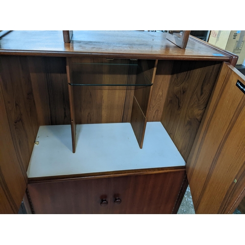 559 - A Younger Ltd mid 20th century teak drinks cabinet, twin doors revealing a fitted interior of glass ... 