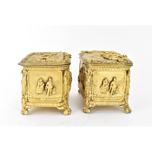 106 - Two 19th century French gilt metal jewellery caskets, each decorated in relief with five panels depi... 