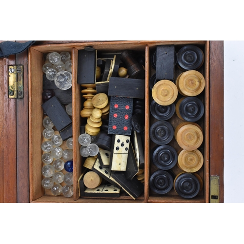 110 - An Edwardian mahogany games compendium, containing a solitaire board with marbles, draught pieces, c... 