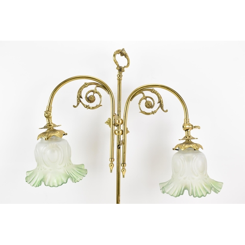 152 - An early 20th century brass adjustable table lamp, having two branches with opalescent green shades,... 