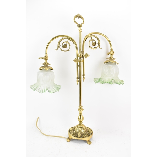 152 - An early 20th century brass adjustable table lamp, having two branches with opalescent green shades,... 