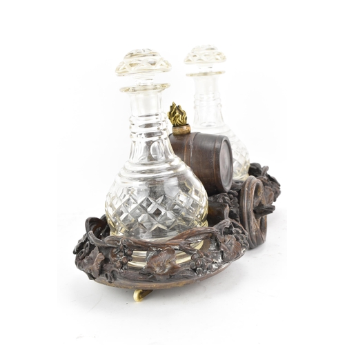 154 - A late 19th century black forest oak carved wine decanter wagon, the centre with a barrel inset with... 