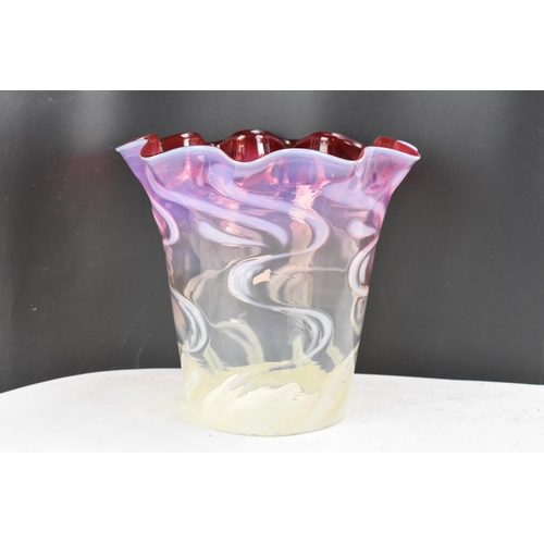 160 - A Victorian glass shade having a wavy formed rim, vaseline glass merging into cranberry surrounded w... 