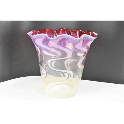 160 - A Victorian glass shade having a wavy formed rim, vaseline glass merging into cranberry surrounded w... 