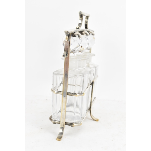 171 - An Art Deco French silver plated liquor tantalus, having three decanters, the frame having a hinged ... 