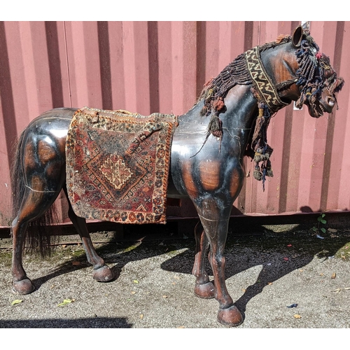 189 - A large Pakistani treen model of a horse with hand woven headstall, browband and seat, 134cm high x ... 