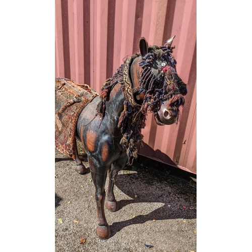 189 - A large Pakistani treen model of a horse with hand woven headstall, browband and seat, 134cm high x ... 